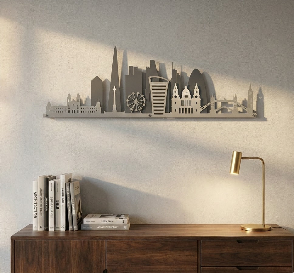 City skyline wall art on a wall above a wooden cabinet with books and a lamp.