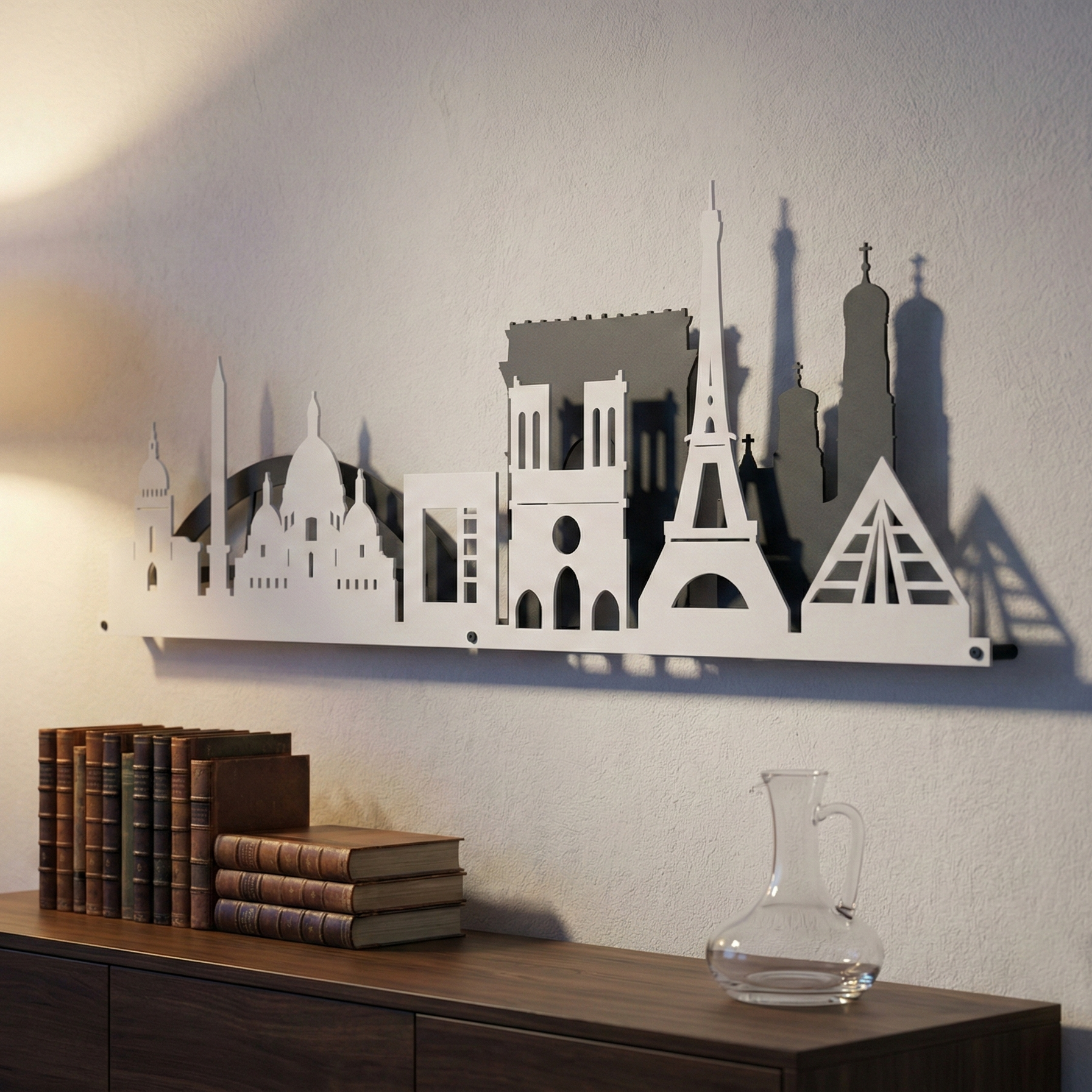 Wall art of a city skyline on a wall above a wooden shelf with books and a decanter.